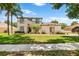 Inviting two-story home featuring a manicured lawn, beautiful landscaping and a charming front entrance at 177 Costa Loop, Auburndale, FL 33823