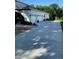Side view of the 3-car garage with long driveway and meticulously maintained landscaping at 177 Costa Loop, Auburndale, FL 33823