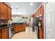 Well-lit kitchen with wood cabinets, granite countertops, stainless steel appliances, and an adjacent dining area at 177 Costa Loop, Auburndale, FL 33823