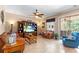 Comfortable living room with tile floors, ceiling fan, entertainment center, and sliding glass doors to the patio at 177 Costa Loop, Auburndale, FL 33823