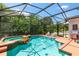 Enclosed swimming pool and hot tub surrounded by mature trees and a screen enclosure at 177 Costa Loop, Auburndale, FL 33823