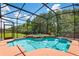 Enclosed pool and hot tub area surrounded by lush trees with bright blue water and a screened enclosure at 177 Costa Loop, Auburndale, FL 33823