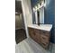 Bathroom features a wood vanity with a white countertop, a large mirror, and dark blue shiplap at 1781 Lakehill Dr, Winter Haven, FL 33884