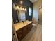 Bathroom features a wood vanity with a white countertop, a large mirror, and modern lighting at 1781 Lakehill Dr, Winter Haven, FL 33884