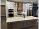 Kitchen featuring a quartz countertop island, modern appliances, custom cabinets, and stylish backsplash at 1781 Lakehill Dr, Winter Haven, FL 33884