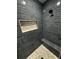 Stylish shower with dark blue tiles, pebble floor, and a convenient niche for storage at 1781 Lakehill Dr, Winter Haven, FL 33884