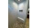 Modern shower with marble-look tiles, pebble floor, and convenient corner seating at 1781 Lakehill Dr, Winter Haven, FL 33884