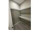Spacious walk-in closet with white shelving and wood-look tile flooring for organized storage at 1781 Lakehill Dr, Winter Haven, FL 33884