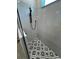 Modern bathroom shower features decorative geometric tile floor and gray tiled walls at 1787 Lakehill Dr, Winter Haven, FL 33884