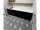 Bright laundry room featuring black shaker cabinets, white quartz countertops and patterned floor tiles at 1787 Lakehill Dr, Winter Haven, FL 33884
