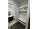 Bright mudroom with a built-in bench, coat hooks, open shelving, and patterned tile leading to a half bathroom at 1787 Lakehill Dr, Winter Haven, FL 33884