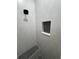 Modern shower featuring light gray vertical tiling, a black hexagonal tiled floor and a shower niche at 1787 Lakehill Dr, Winter Haven, FL 33884