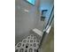 Modern walk-in shower featuring gray tiles, a shower bench, and glass enclosure at 1787 Lakehill Dr, Winter Haven, FL 33884