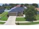 Aerial view of a single-story home with a manicured lawn, stone accents, and a two-car garage at 186 Viola Dr, Auburndale, FL 33823