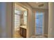 Hallway view of a full bath with shower and dark cabinets at 186 Viola Dr, Auburndale, FL 33823