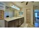 Well-lit bathroom with a double sink vanity, large mirror, and walk-in closet at 186 Viola Dr, Auburndale, FL 33823