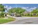 Community entrance with manicured landscaping, signage, and a security gate at 186 Viola Dr, Auburndale, FL 33823