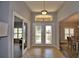 Inviting foyer with decorative glass doors, chandelier, transom window, and elegant tile flooring at 186 Viola Dr, Auburndale, FL 33823