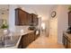 Open kitchen with granite countertops, tile backsplash, dark cabinetry, and stainless steel sink at 186 Viola Dr, Auburndale, FL 33823