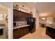 Farmhouse kitchen with stainless steel refrigerator, granite counters, and dark cabinets at 186 Viola Dr, Auburndale, FL 33823