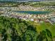 Aerial shot displaying a community of homes around a lake, surrounded by lush green forests and landscaping at 225 Summershore Dr, Auburndale, FL 33823