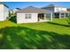 A well-maintained backyard with lush green grass and a covered patio extending from the rear of the home at 225 Summershore Dr, Auburndale, FL 33823