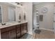Bathroom with dual sinks, shower, and light colored tile floors at 225 Summershore Dr, Auburndale, FL 33823