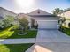 Well-manicured front lawn of a single story home with a two car garage at 225 Summershore Dr, Auburndale, FL 33823