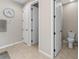 Hallway featuring tiled floors and multiple white doors, one leading to the toilet at 225 Summershore Dr, Auburndale, FL 33823