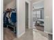 Hallway featuring tiled floors, an open closet with clothes and a view of the bedroom at 225 Summershore Dr, Auburndale, FL 33823