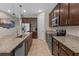 Well-equipped kitchen with granite counters, stainless appliances, dark wood cabinets, and island with barstool seating at 225 Summershore Dr, Auburndale, FL 33823