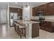 Beautiful kitchen with granite countertops, stainless steel appliances, dark wood cabinets, island, and barstool seating at 225 Summershore Dr, Auburndale, FL 33823