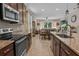 Open kitchen showcasing tile flooring, stainless steel appliances, and an island with seating, flowing into the living area at 225 Summershore Dr, Auburndale, FL 33823