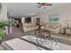Comfortable living room with carpet flooring, neutral walls, ceiling fan, and seamless flow into the kitchen at 225 Summershore Dr, Auburndale, FL 33823