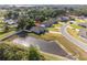 An aerial view showcases a single-Gathering home with a private pond and a spacious backyard at 230 Cove At Eagle Lake Cir, Eagle Lake, FL 33839
