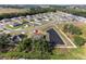 An aerial view showcases a single-Gathering home with a private pond and a spacious backyard at 230 Cove At Eagle Lake Cir, Eagle Lake, FL 33839