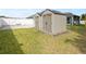 Lush, green backyard featuring two storage sheds, framed by a white fence at 230 Cove At Eagle Lake Cir, Eagle Lake, FL 33839