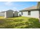 Spacious backyard with lawn, perimeter fence, and two convenient storage sheds at 230 Cove At Eagle Lake Cir, Eagle Lake, FL 33839