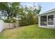 Beautifully landscaped backyard with lush lawn, privacy fence, and screened-in patio at 230 Cove At Eagle Lake Cir, Eagle Lake, FL 33839