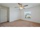 Light-filled bedroom with ceiling fan, closet, and window; carpeted flooring and white walls create a peaceful retreat at 230 Cove At Eagle Lake Cir, Eagle Lake, FL 33839