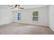 Inviting bedroom featuring neutral carpeting, two windows, and a ceiling fan at 230 Cove At Eagle Lake Cir, Eagle Lake, FL 33839