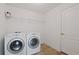 Tiled laundry area with modern appliances and storage at 230 Cove At Eagle Lake Cir, Eagle Lake, FL 33839