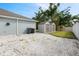 Gravel yard, fenced with perimeter fence, bins, and two storage sheds in background at 230 Cove At Eagle Lake Cir, Eagle Lake, FL 33839