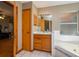 Relaxing bathroom with a soaking tub, wood vanity, and a door to the other parts of the house at 2390 Lake Easy Rd, Babson Park, FL 33827
