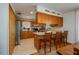 The kitchen features wood cabinets, stainless steel appliances, breakfast bar with seating, and tile flooring at 2390 Lake Easy Rd, Babson Park, FL 33827