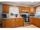 Bright kitchen featuring stainless steel appliances, wood cabinets, a window, and a view of the outdoors at 2390 Lake Easy Rd, Babson Park, FL 33827