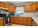 Bright kitchen featuring stainless steel appliances, oak cabinets, a window, and a view of the outdoors at 2390 Lake Easy Rd, Babson Park, FL 33827