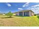 Expansive backyard features a well-kept lawn, young palm tree, and a screened-in lanai at 2577 Canyon Crest Dr, Lakeland, FL 33811