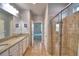 Bright bathroom featuring a double vanity with granite countertop, a glass-enclosed shower, and a view to the bedroom at 2577 Canyon Crest Dr, Lakeland, FL 33811