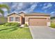 Inviting single-story home featuring a well-manicured lawn and a two-car garage at 2577 Canyon Crest Dr, Lakeland, FL 33811
